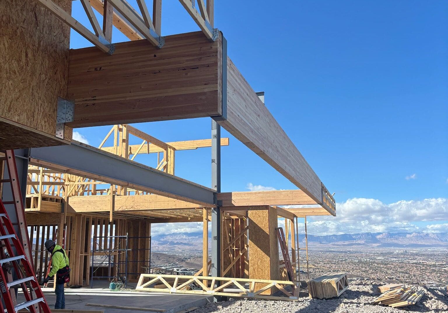 Construction site with wooden framing and clear blue sky in a desert landscape.
